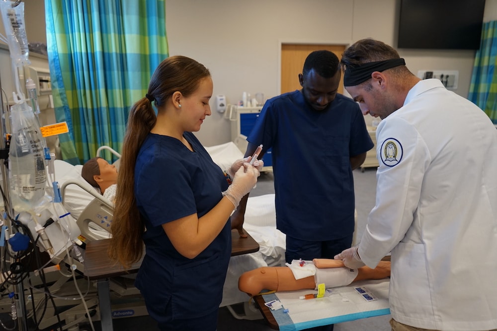 A group of nursing students in a nursing simulation lab