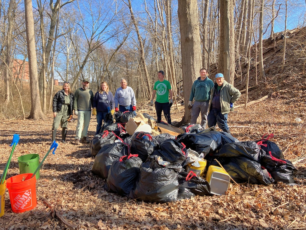 A group of people in a forrest, clean and collected garbage with garbage bags