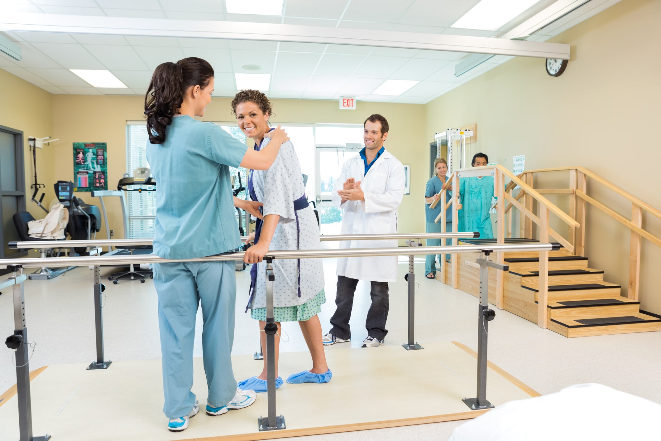 Medical professional helping a woman stand