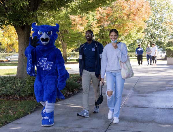 Owl mascot and people walking