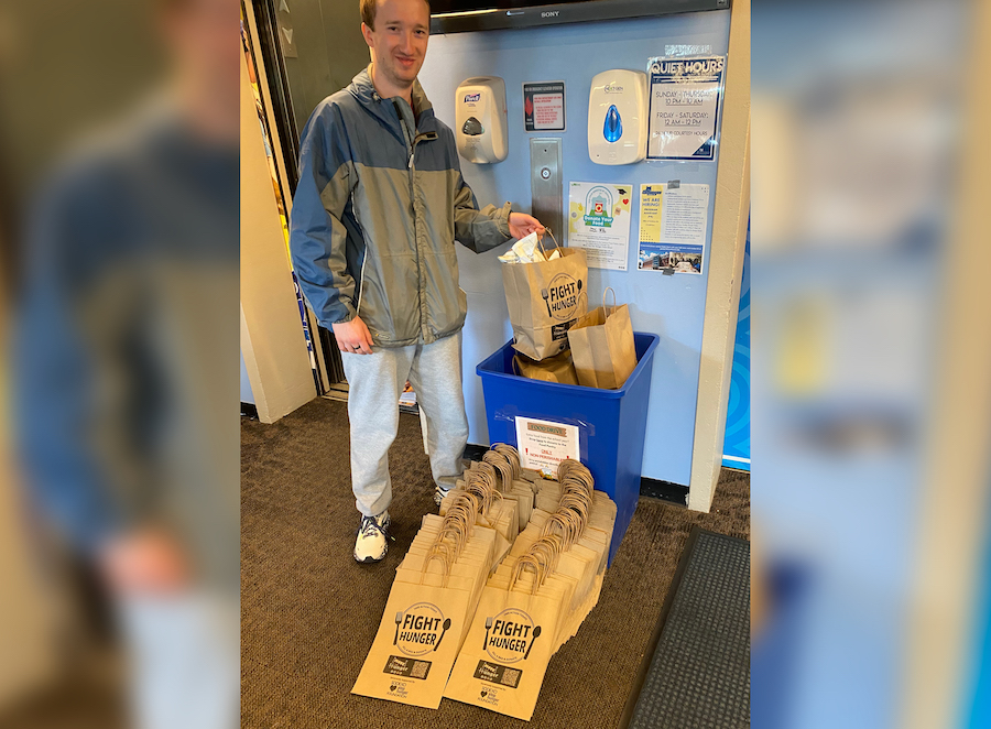 Volunteer with paper bags labeled Fight Hunger