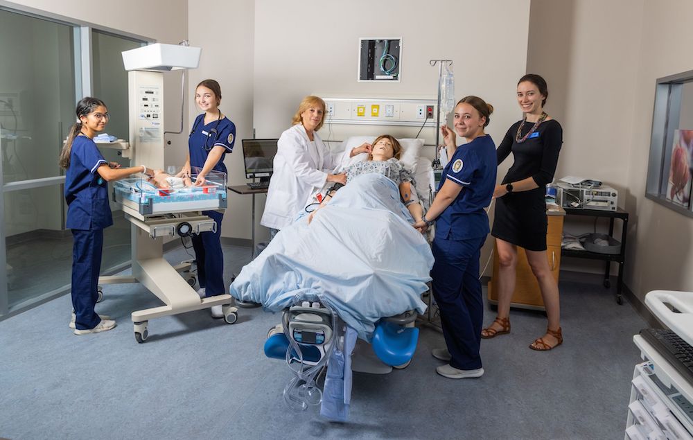 A group of nursing students working in a nursing setting simulation