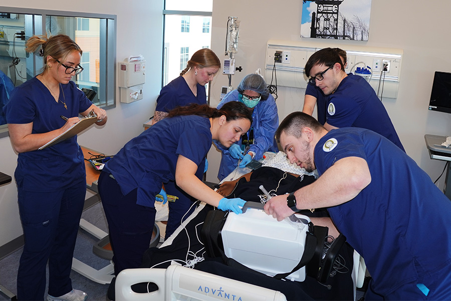 A group of nursing students working in a nursing setting simulation