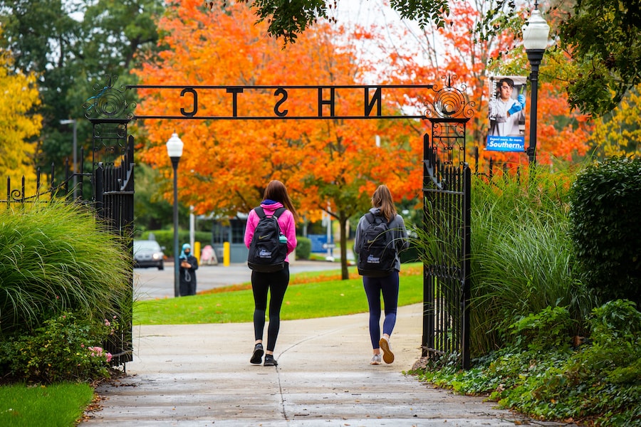 Two students walking through a gate in the campus