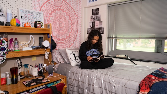 Student reading a book in her dorm room