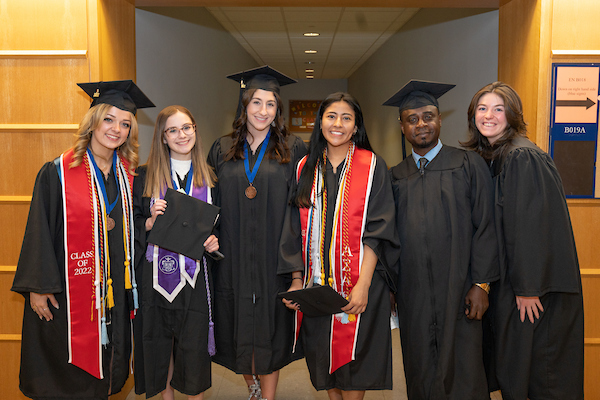 A group of students at a graduation with cap and gown