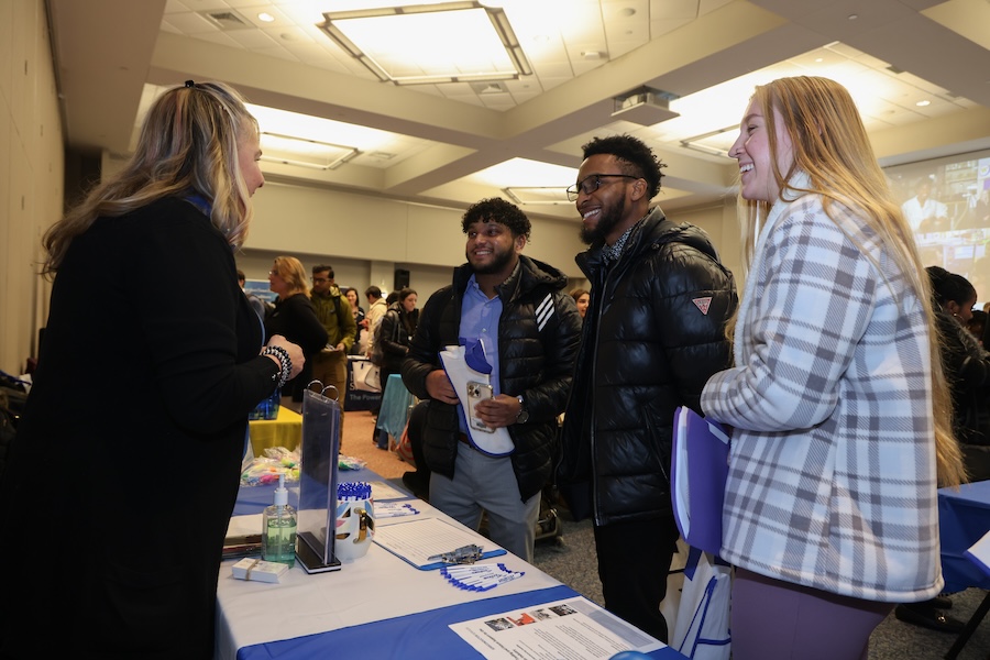 Career fair event with many students speaking with employers