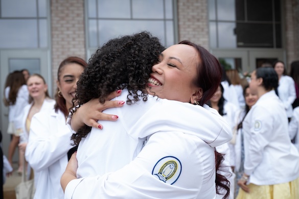 New nurses hugging after receiving their nursing pins