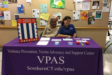 Two staff members at a table with VPAS promotional materials