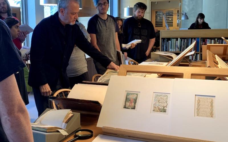 Professor Tony Rosso displaying William Blake's watercolors to Southern English majors