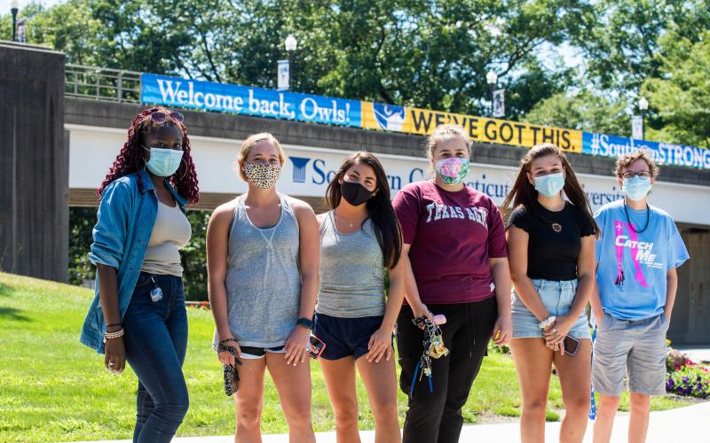 students wearing masks in front of the bridge