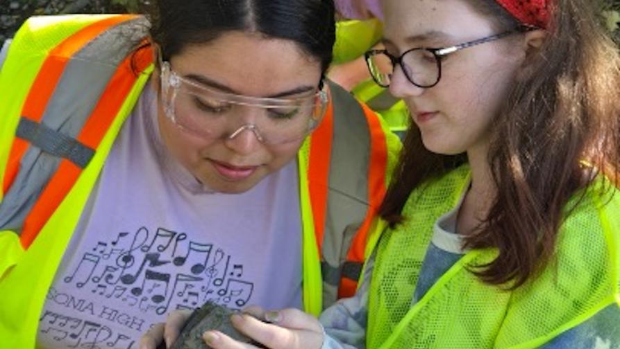 Two Earth Science students observing a stone.