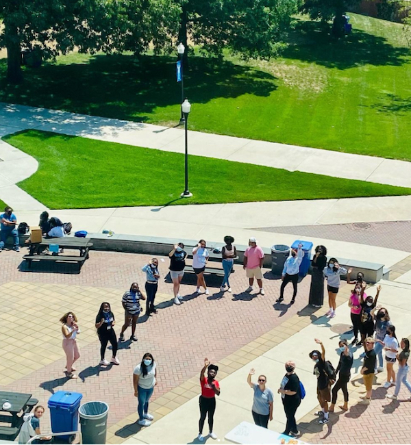 A group of students forming a circle in the academic quad
