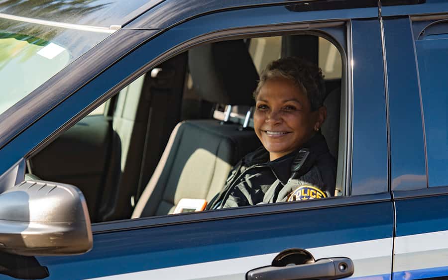 university police officer sits in a university police cruiser