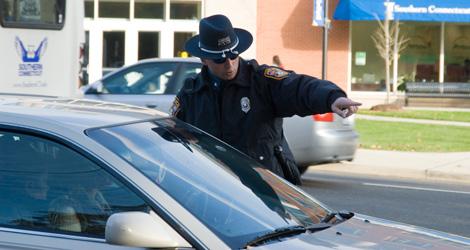 A police officer talking to the driver in a stopped vehicle