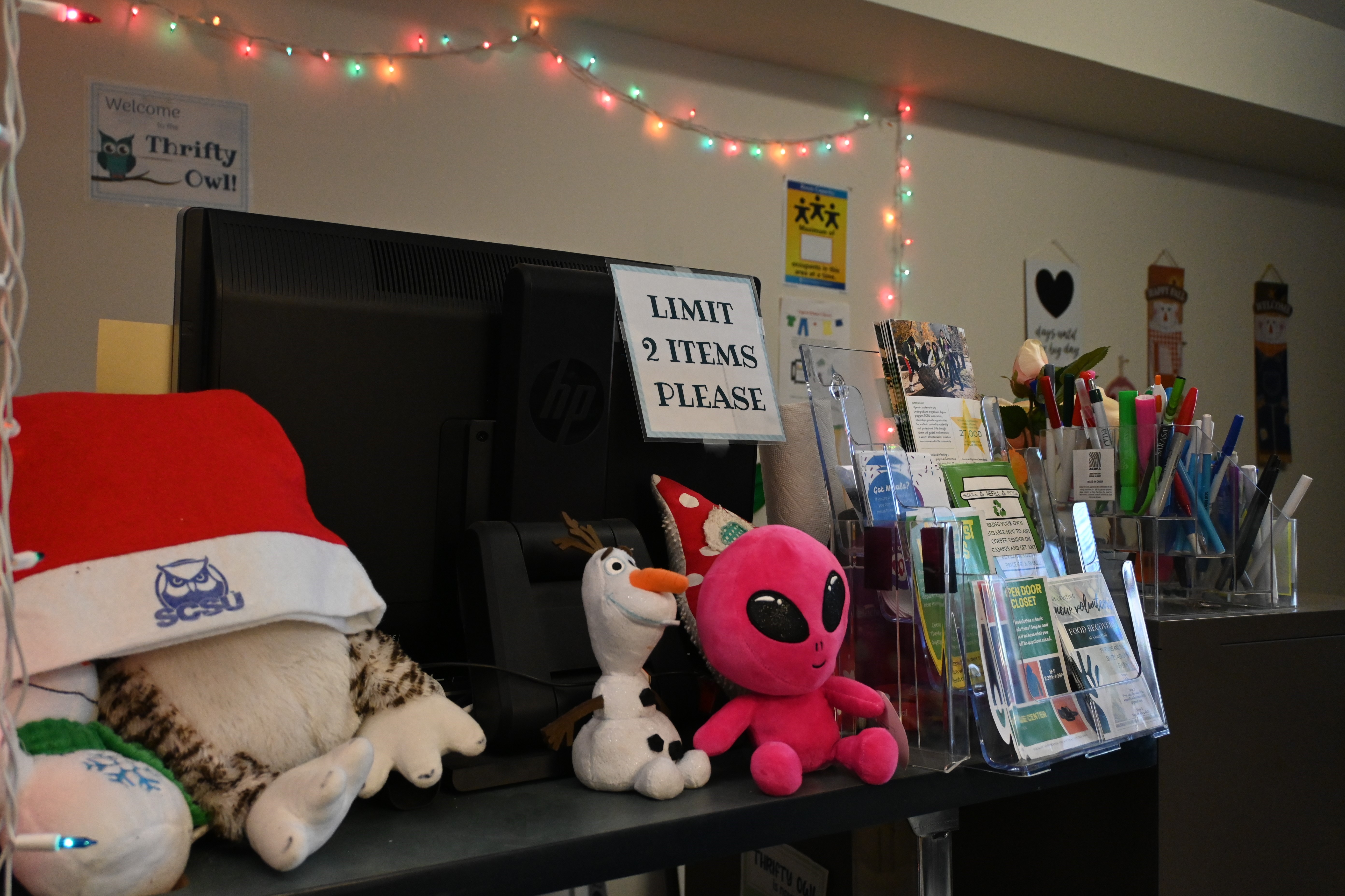 A shelf with flyers and university merchandise