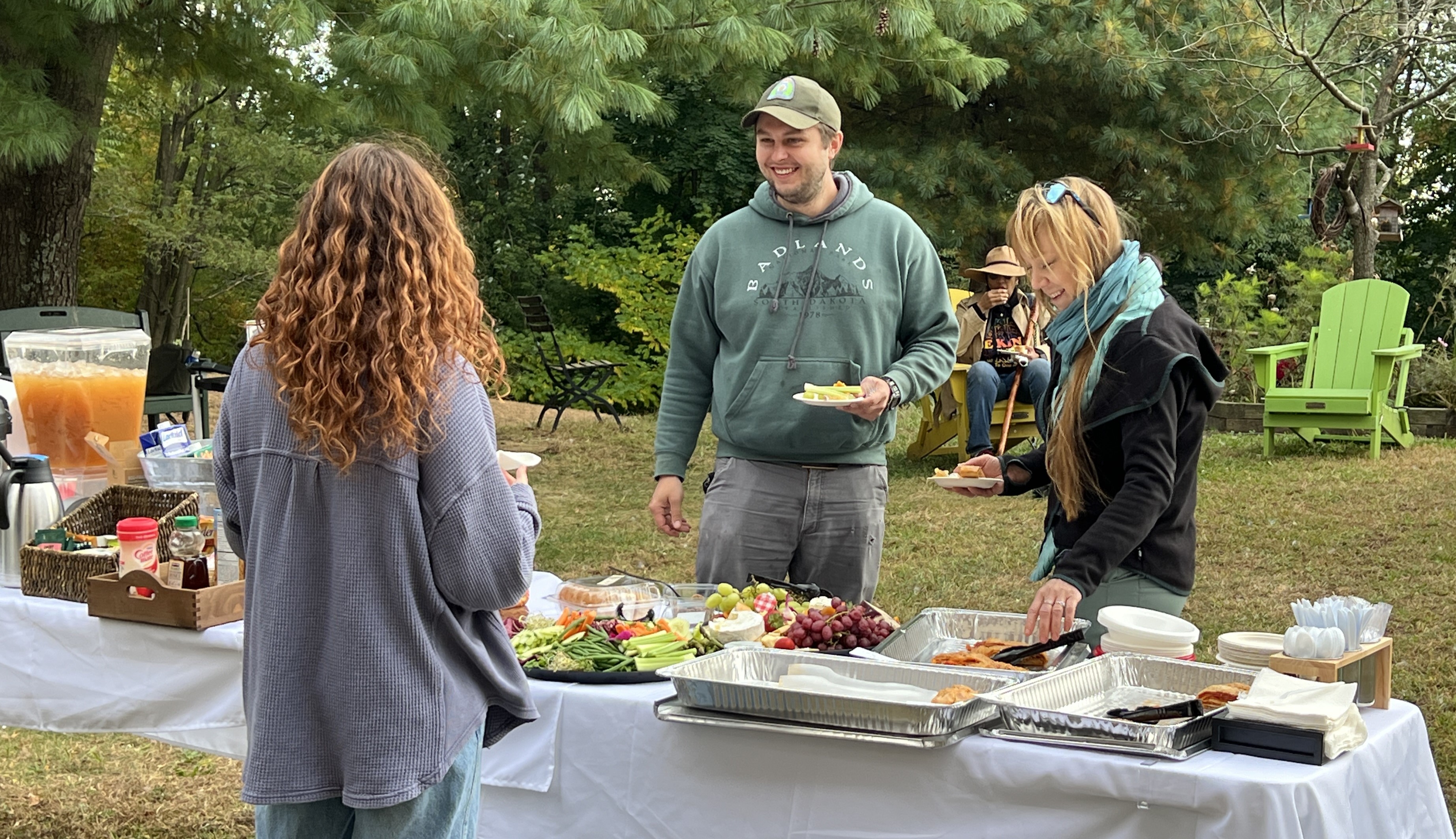 Students gathering around the table to eat food and talk with one another.