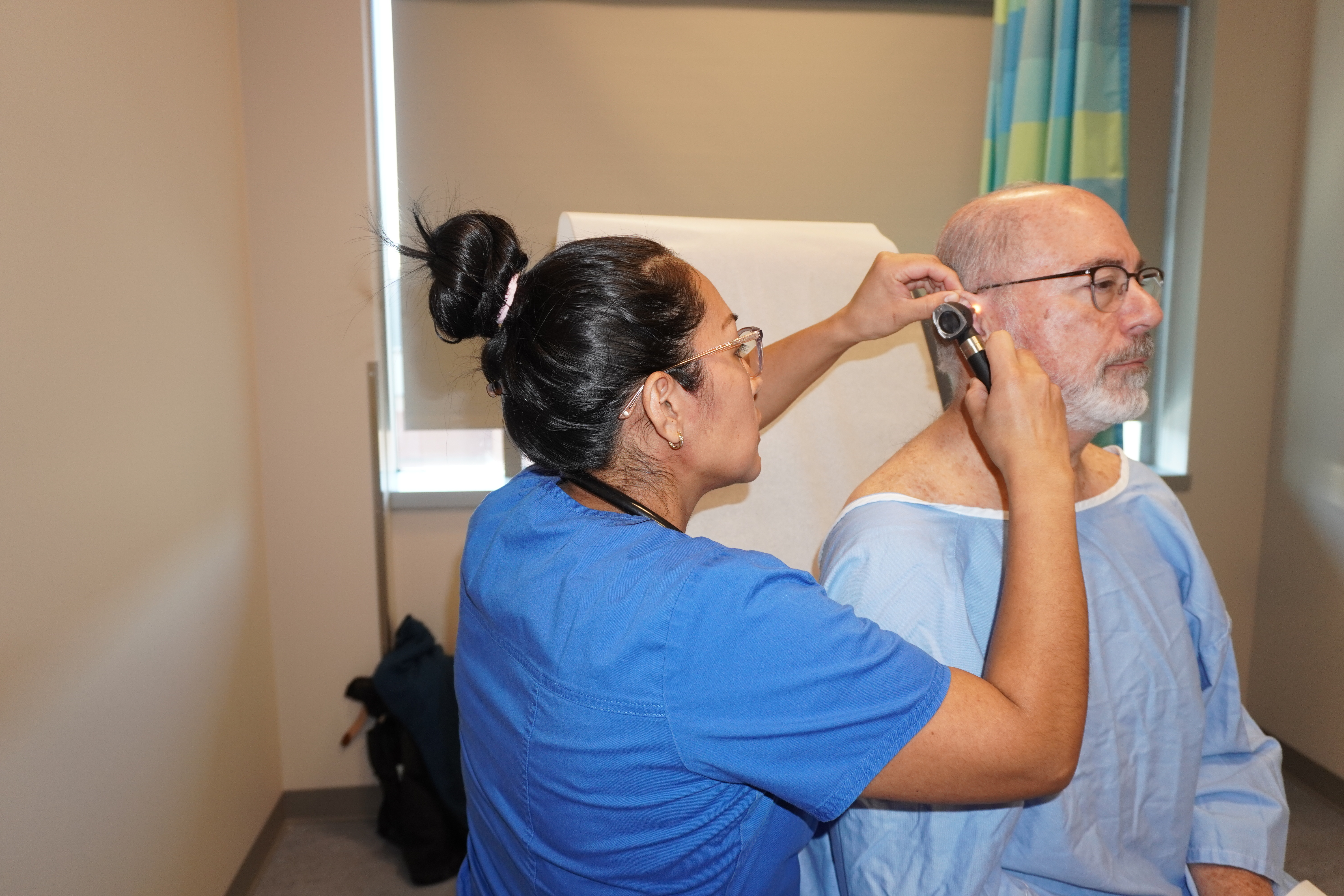 A nursing student performing a checkup on a standardized patient.